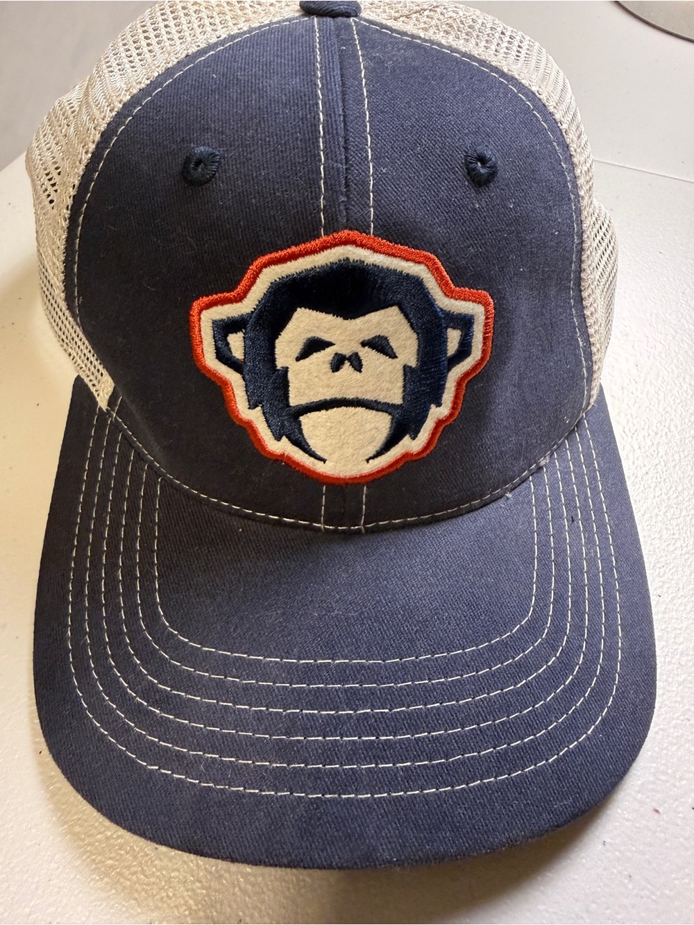 Howler Brothers Classic Monkey Mascot Patch Mesh Trucker Hat in Navy & Tan
Sig
